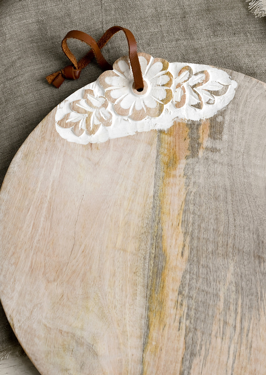 2: A round wooden cutting board with shabby chic floral detailing.