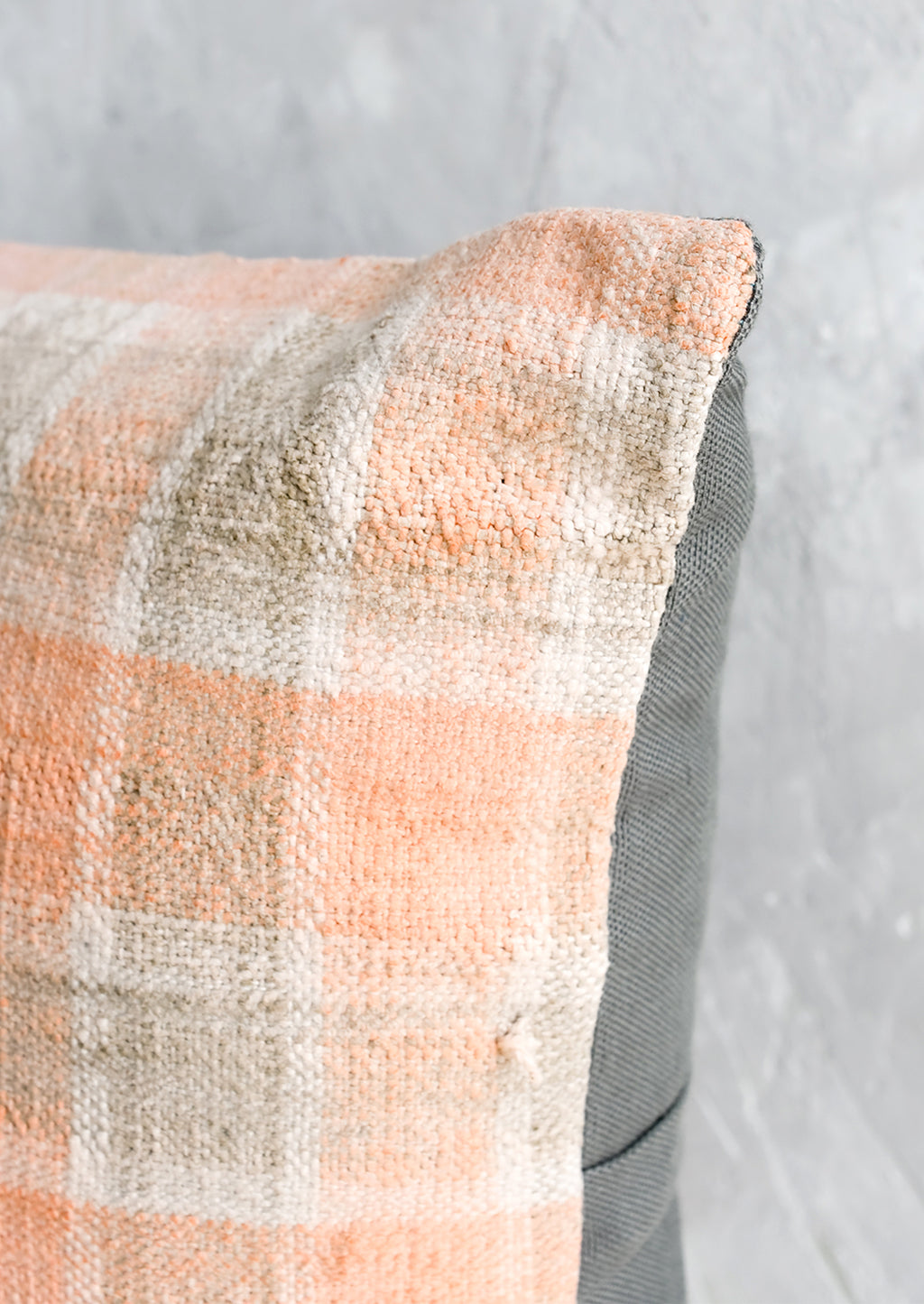 3: A square kilim throw pillow in peach and grey gingham with grey canvas backing.