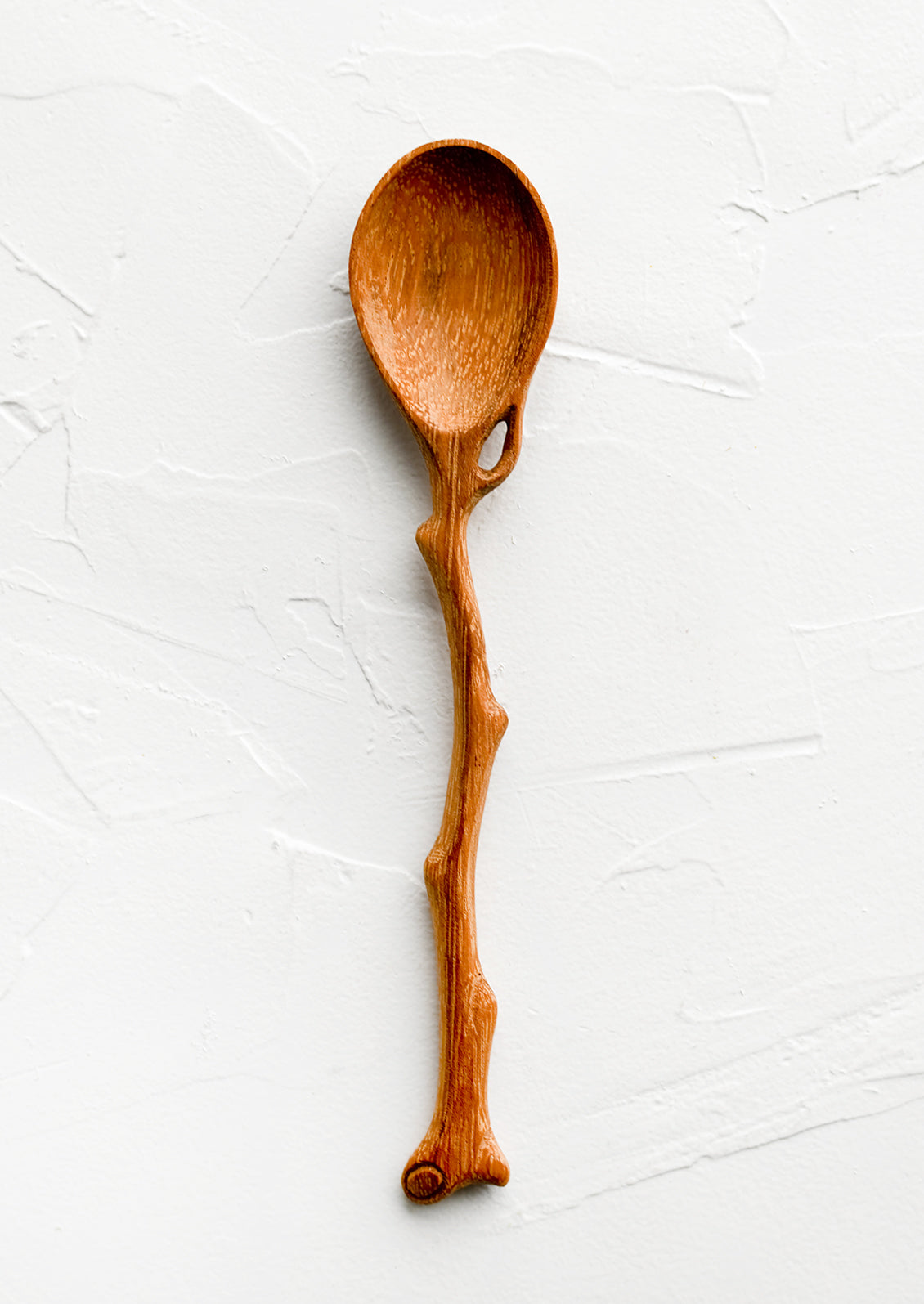 A wooden spoon in shape of tree branch.
