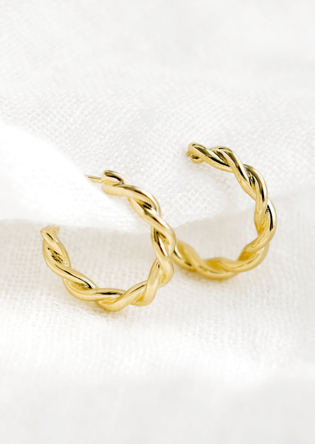 1: A pair of gold twist hoop earrings.