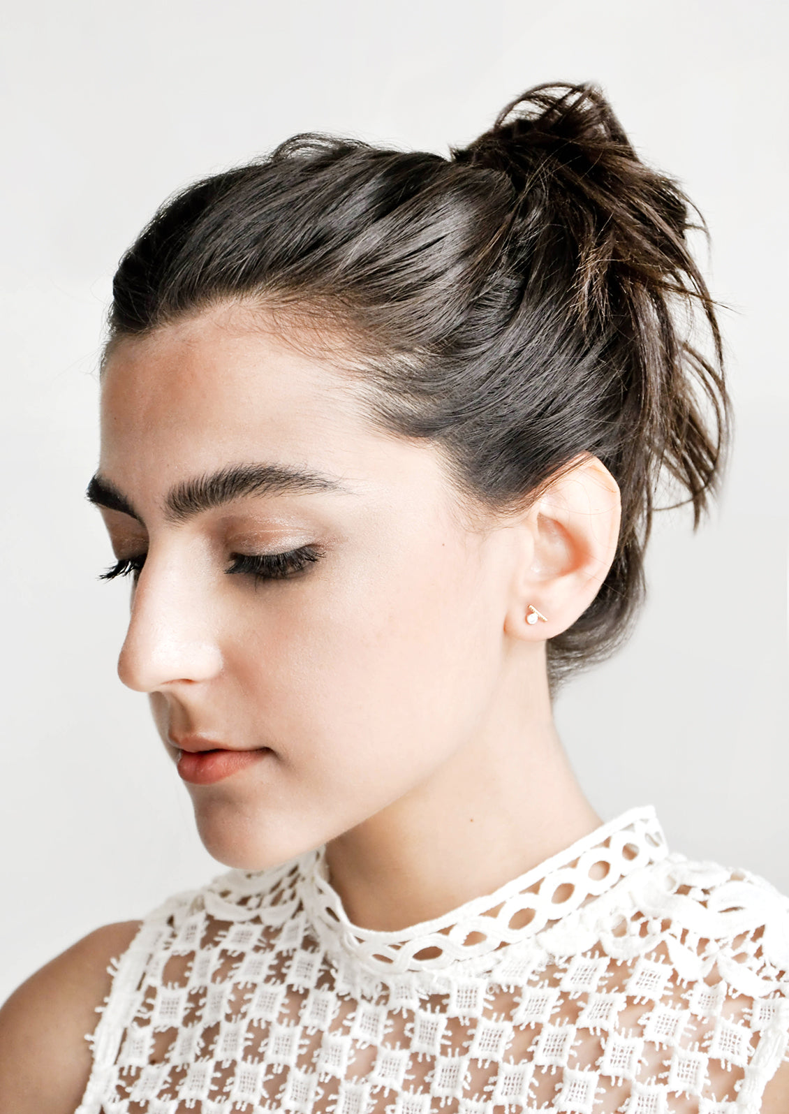 Model shot showing woman wearing earrings and a white top.