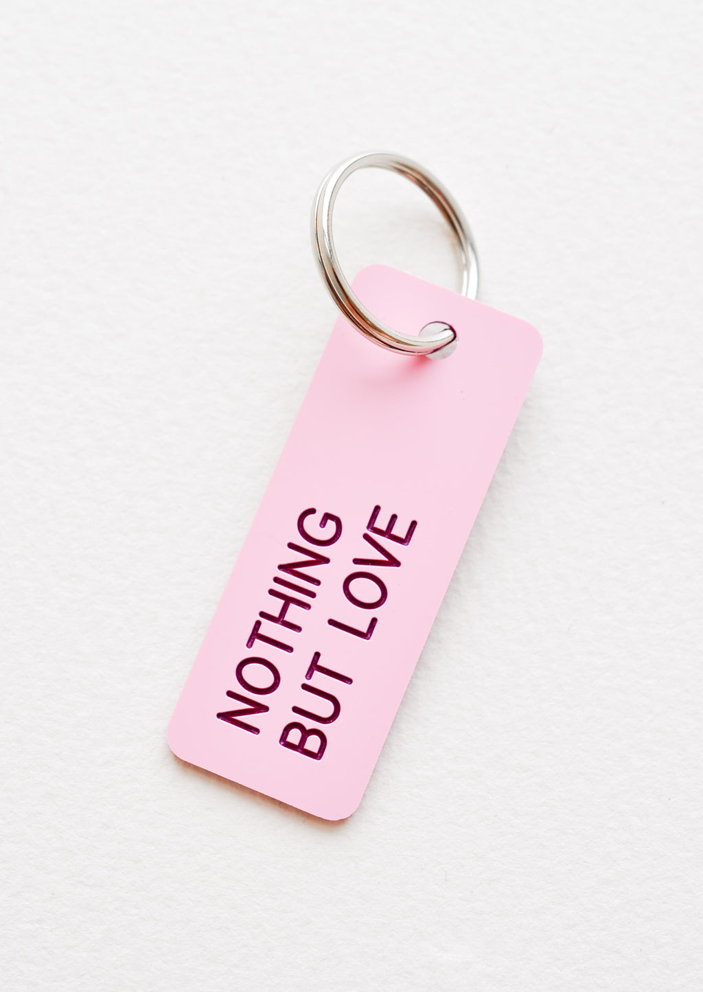 Nothing But Love: Small acrylic keychain, pink background with red words that says "NOTHING BUT LOVE"