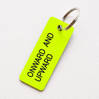 Onward And Upward: Small acrylic keychain, neon yellow background with black words that says "ONWARD AND UPWARD"