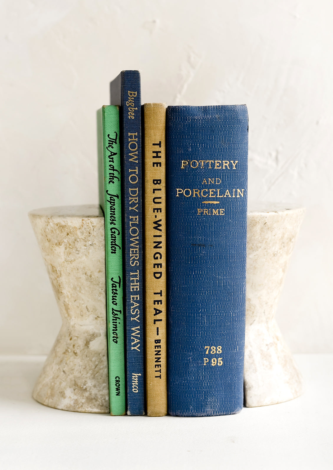A pair of hourglass shaped bookends in tan marble.
