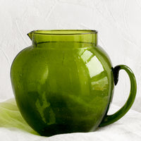 1: A green glass pitcher with large, rounded shape.