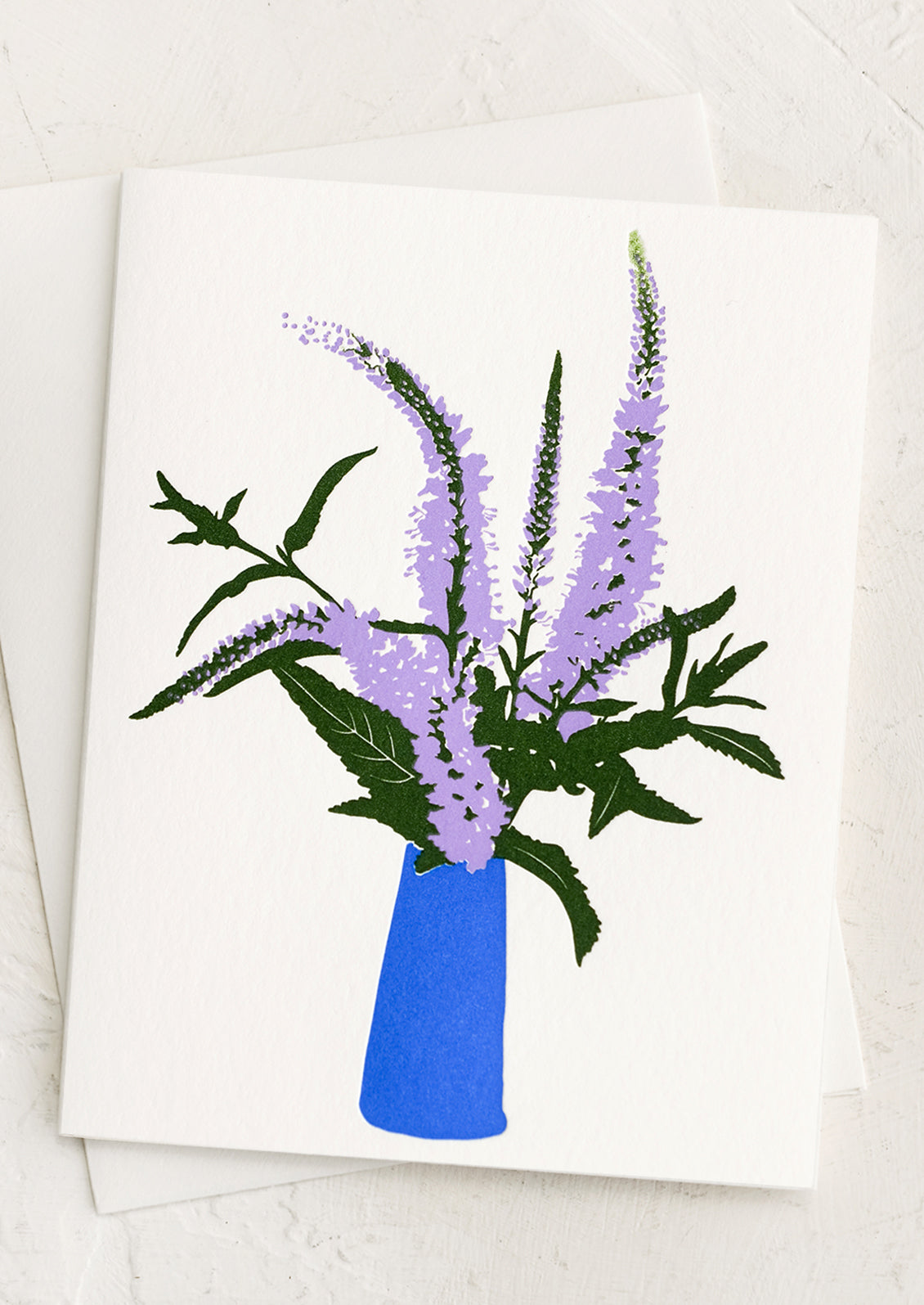 A letterpress printed card with purple veronica flowers in bright blue vase.