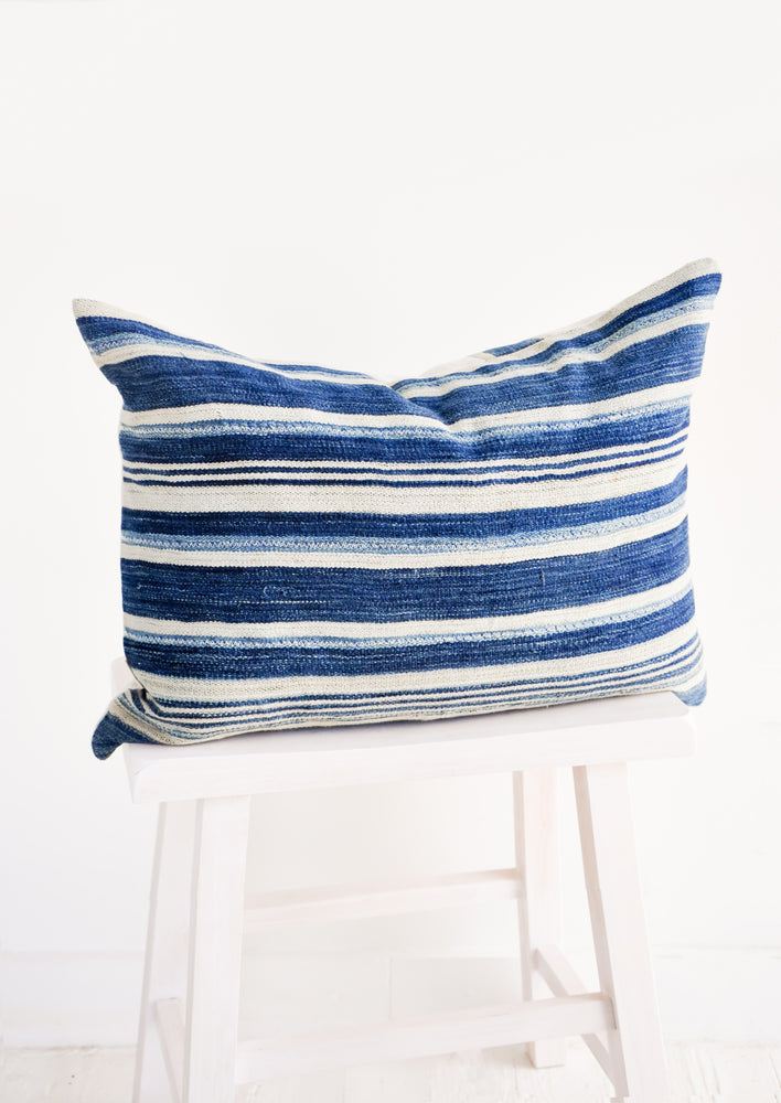 A lumbar throw pillow made from striped indigo & white vintage fabric.