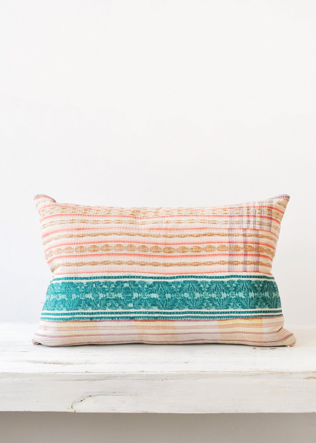 2: A multicolored pillow made of vintage quilt fabric.