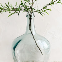 1: A large bottle shaped glass vase with branch.