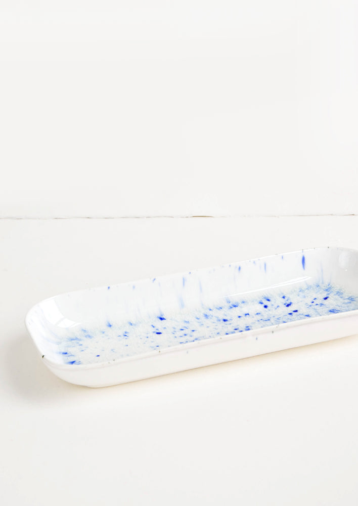Long white rectangular rimmed dish with blue splatter pattern.