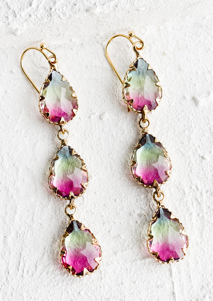 A pair of drop earrings with three stacked teardrop stones in watermelon hued glass.