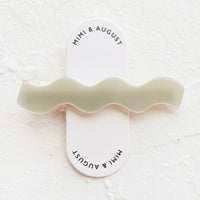 Sage: Sage green hair clip with wavy squiggle shape.