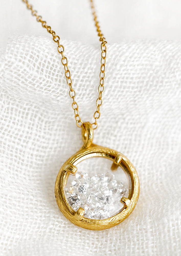 A gold necklace with branch-like circle frame and crystals inside.