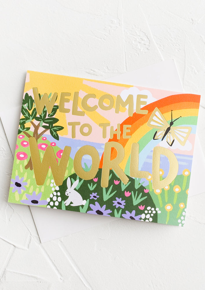 A greeting card with rainbow print reading "Welcome to the world".