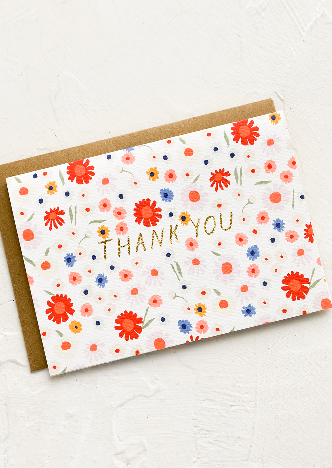 A card with neon floral print and glittery gold text reading "THANK YOU".