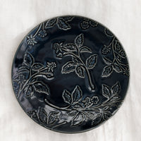 Dark Indigo: A round ceramic dessert plate in indigo with tonal raspberry pattern.