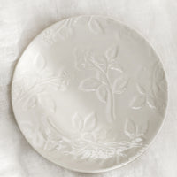 Ivory: A round ceramic dessert plate in ivory with tonal raspberry pattern.