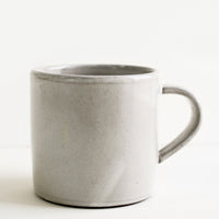 2: A ceramic coffee mug in a simple, classic shape in a white glaze over brown clay.