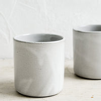 1: Two short ceramic cups in a grey glaze.