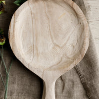 1: A round paddle shaped tray in natural paulownia wood.
