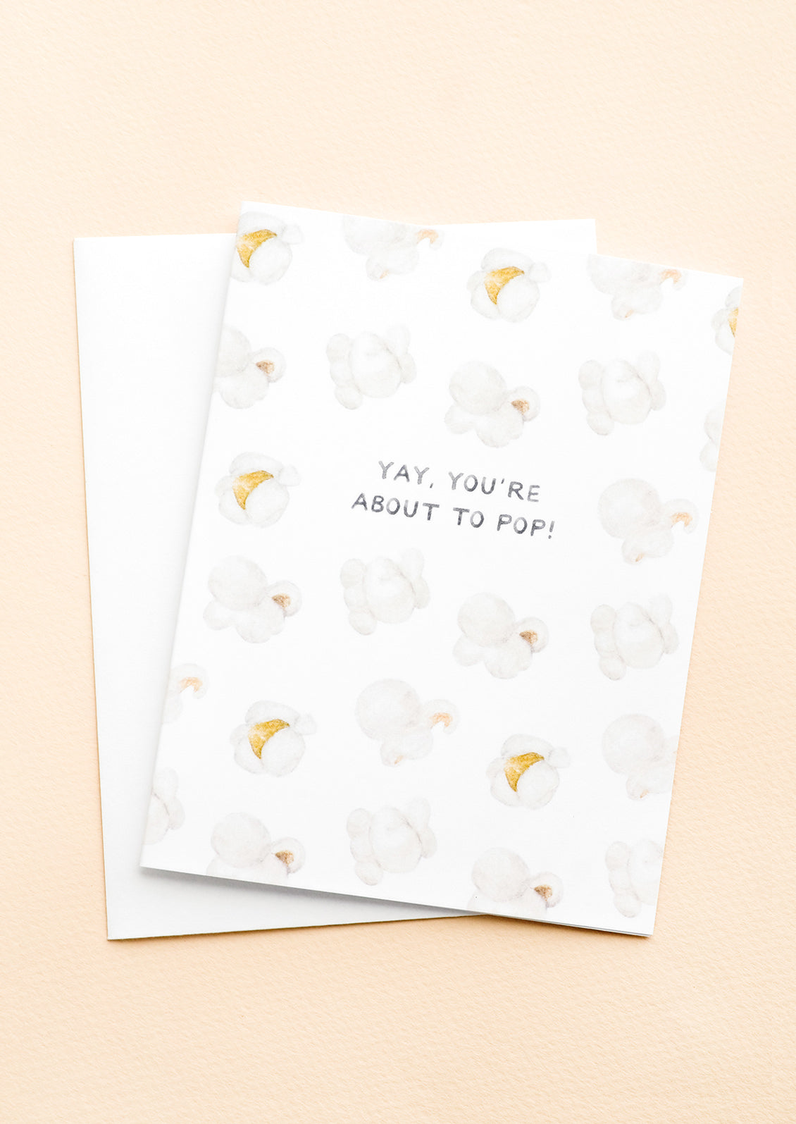 A greeting card with illustrated popcorn print and text at center reading "Yay, You're About To Pop!"