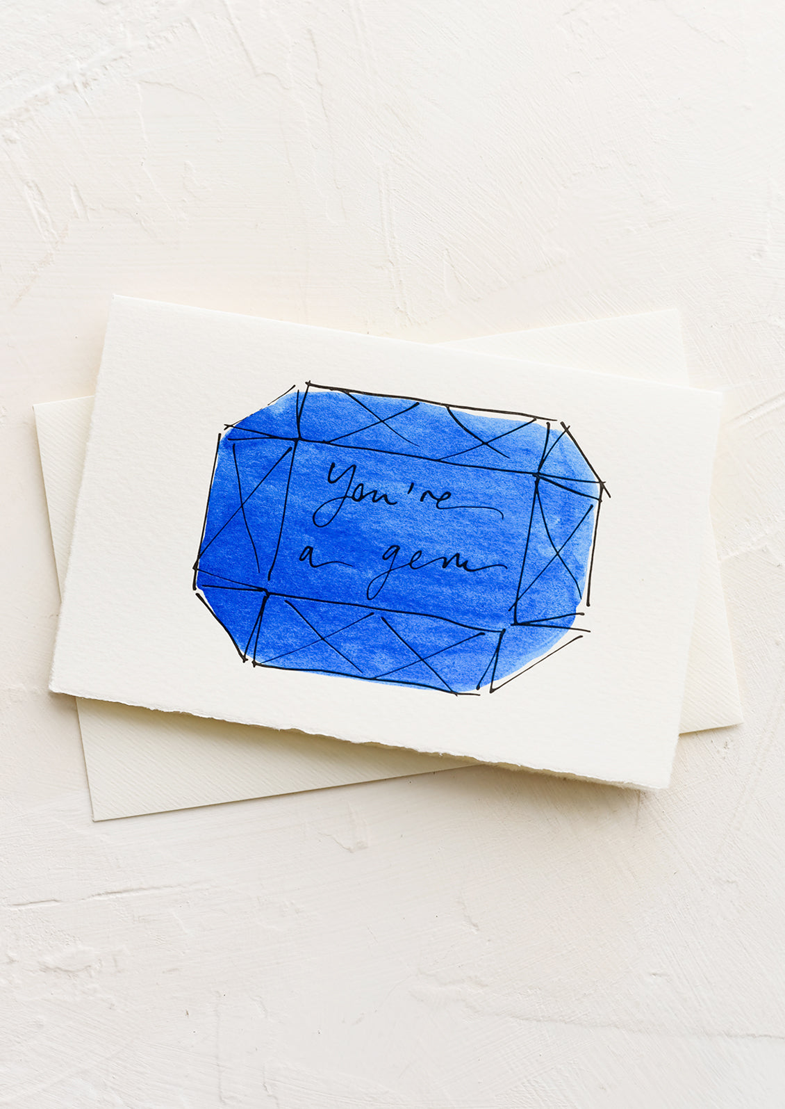 A greeting card with illustration of blue gemstone and text reading "you're a gem".