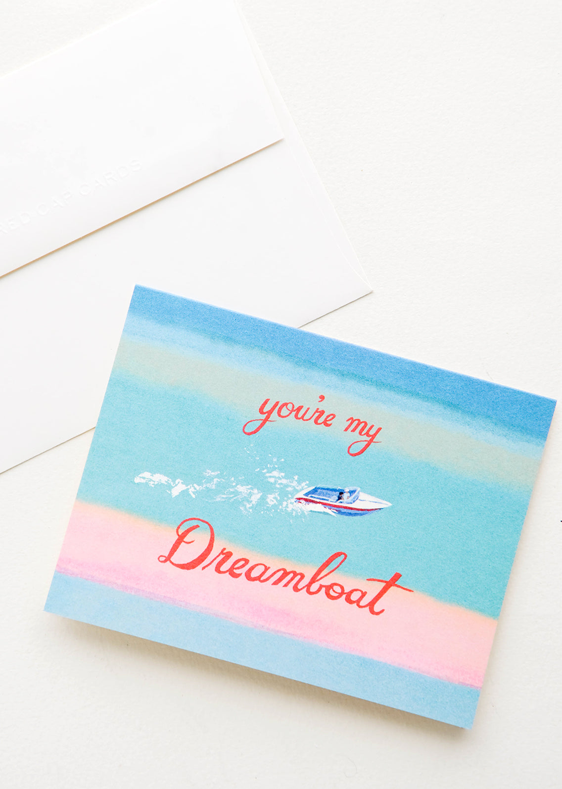 Greeting card with image of a boat speeding through the ocean, red cursive text reads "You're My Dreamboat"