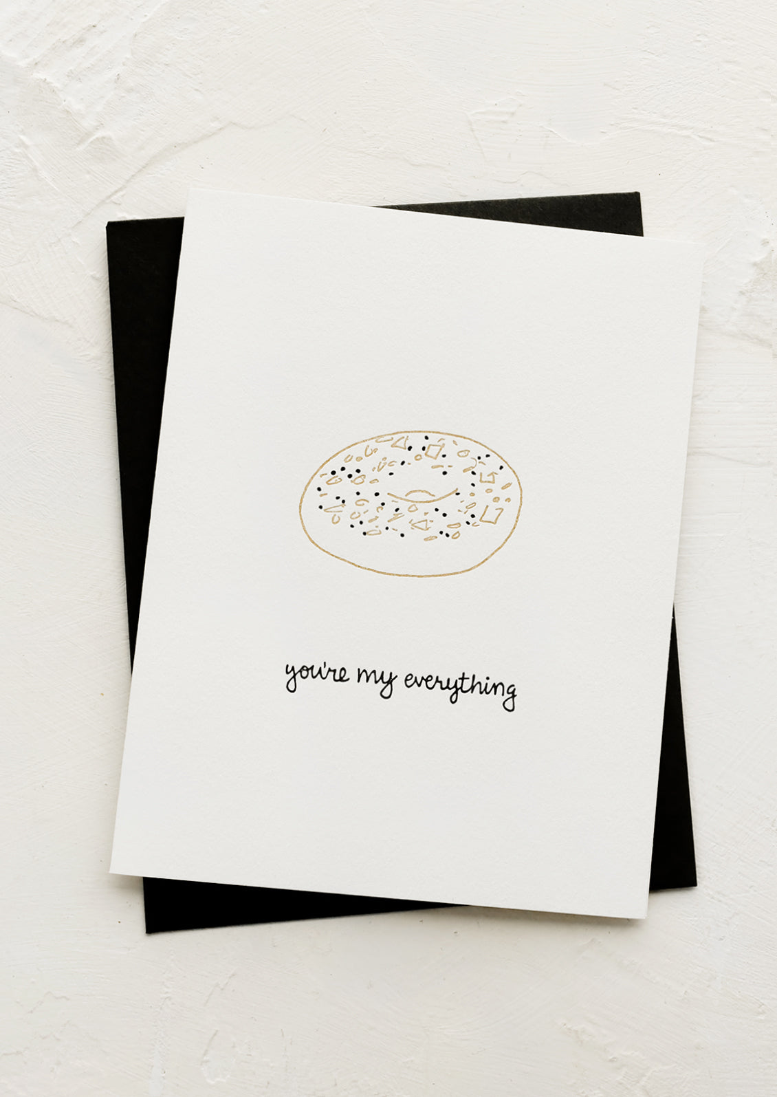 A greeting card with illustration of everything bagel and text below reading "You're my everything".