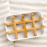 1: A white soap dish with built-in bamboo drainage tray.