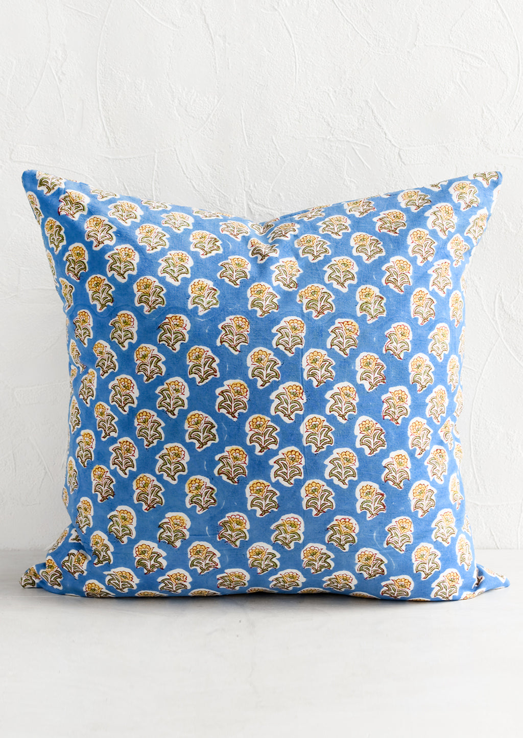 1: A block printed throw pillow in blue and yellow floral.