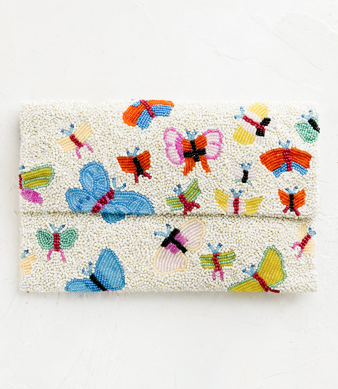 A white beaded clutch with front foldover flap, with multicolor butterfly design.