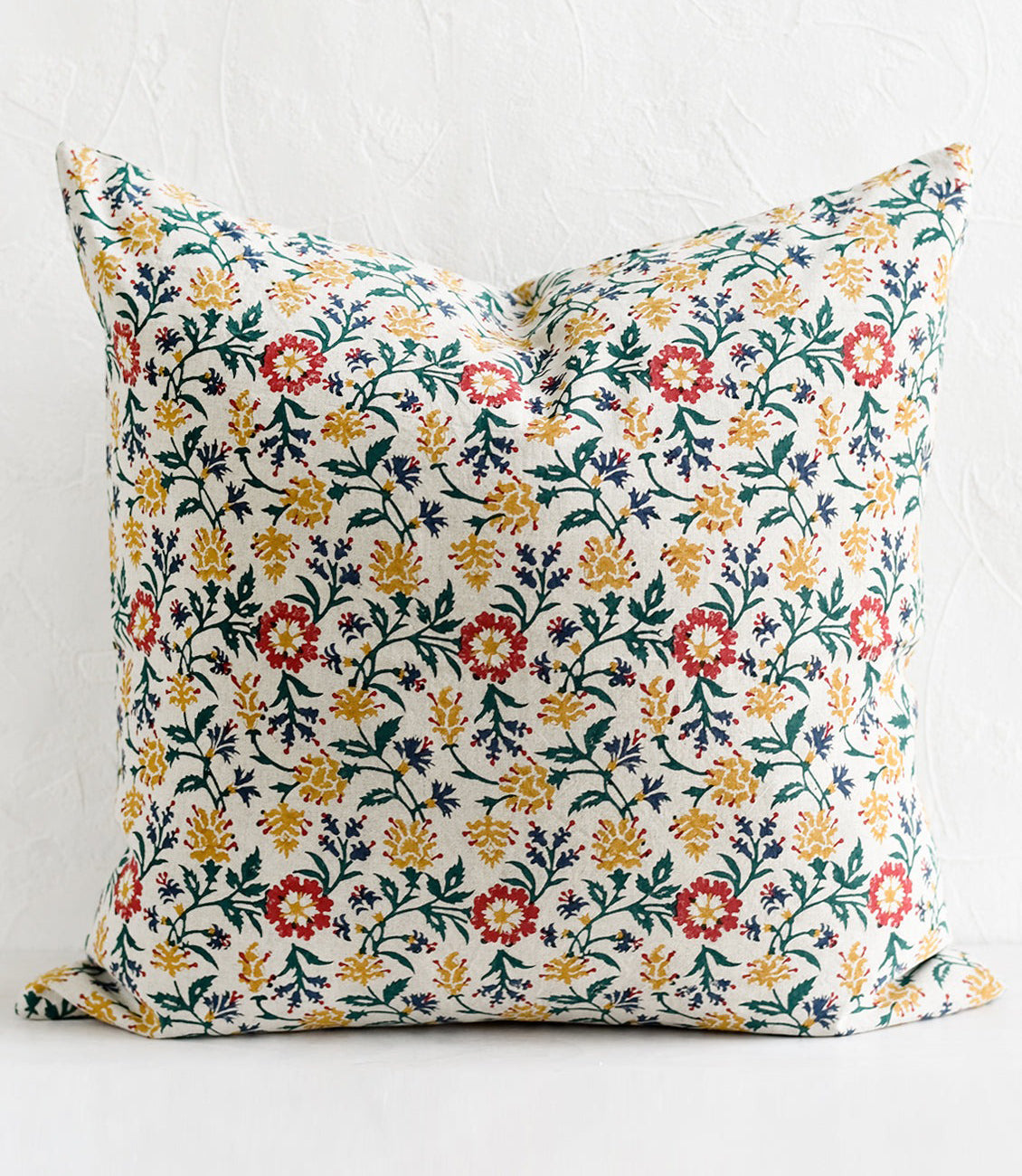 A block printed pillow in floral pattern.