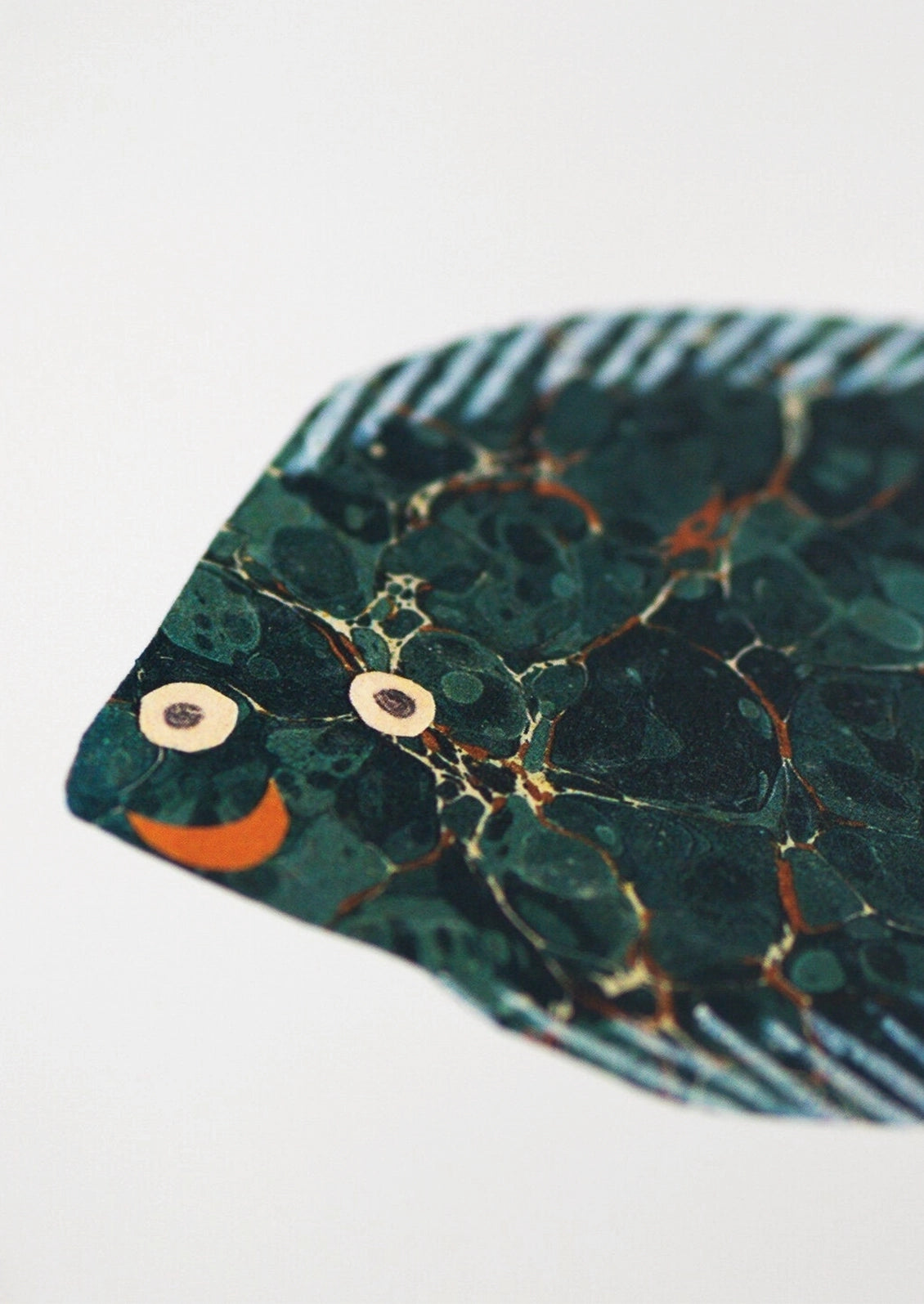 A small art print depicting a fish paper cutting.