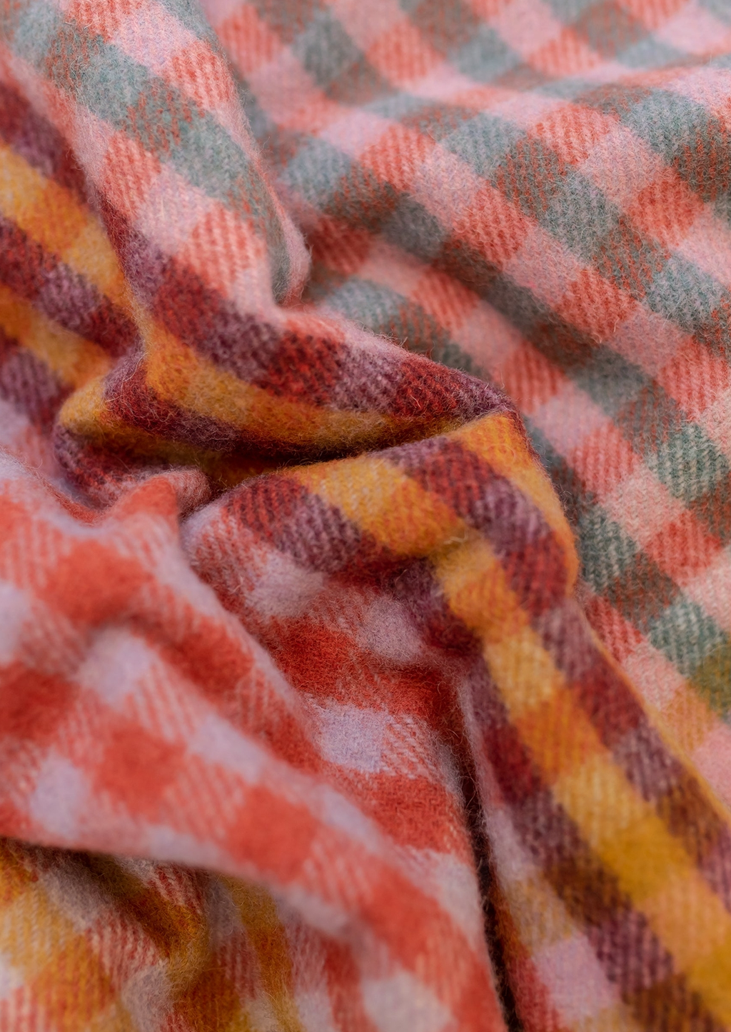 2: A colorful gingham check blanket in tones of lilac, magenta, and yellow.