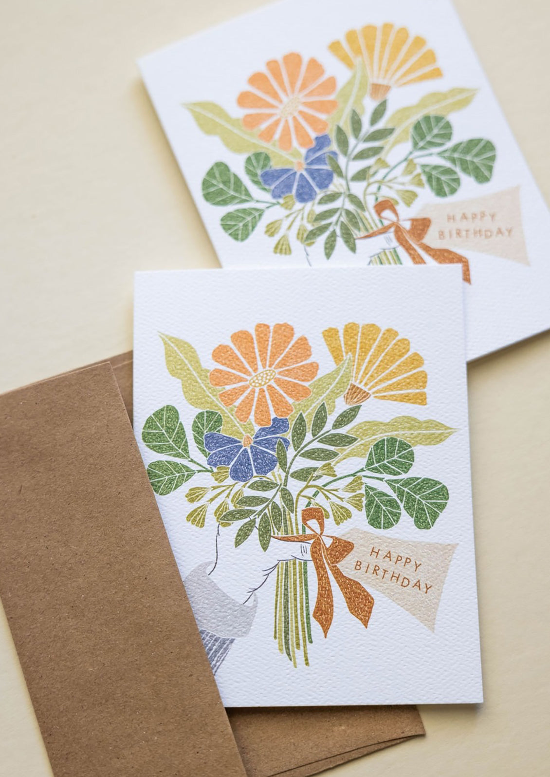 A digital print illustrated card with human hand holding bouquet of flowers and text reads "Happy Birthday".
