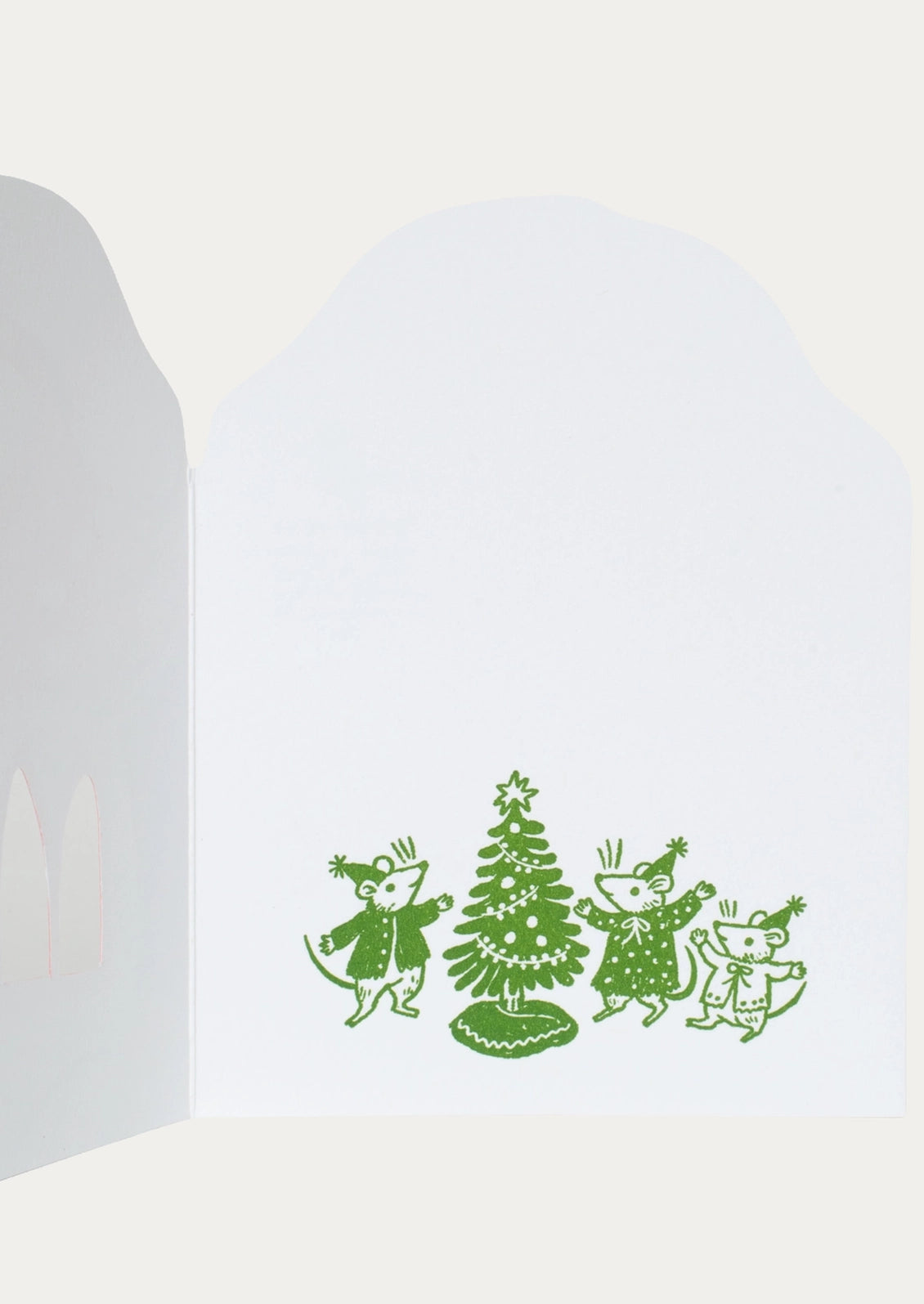 A white greeting card with a green line-art illustration of three children dancing around a Christmas tree, shown against a light gray background.