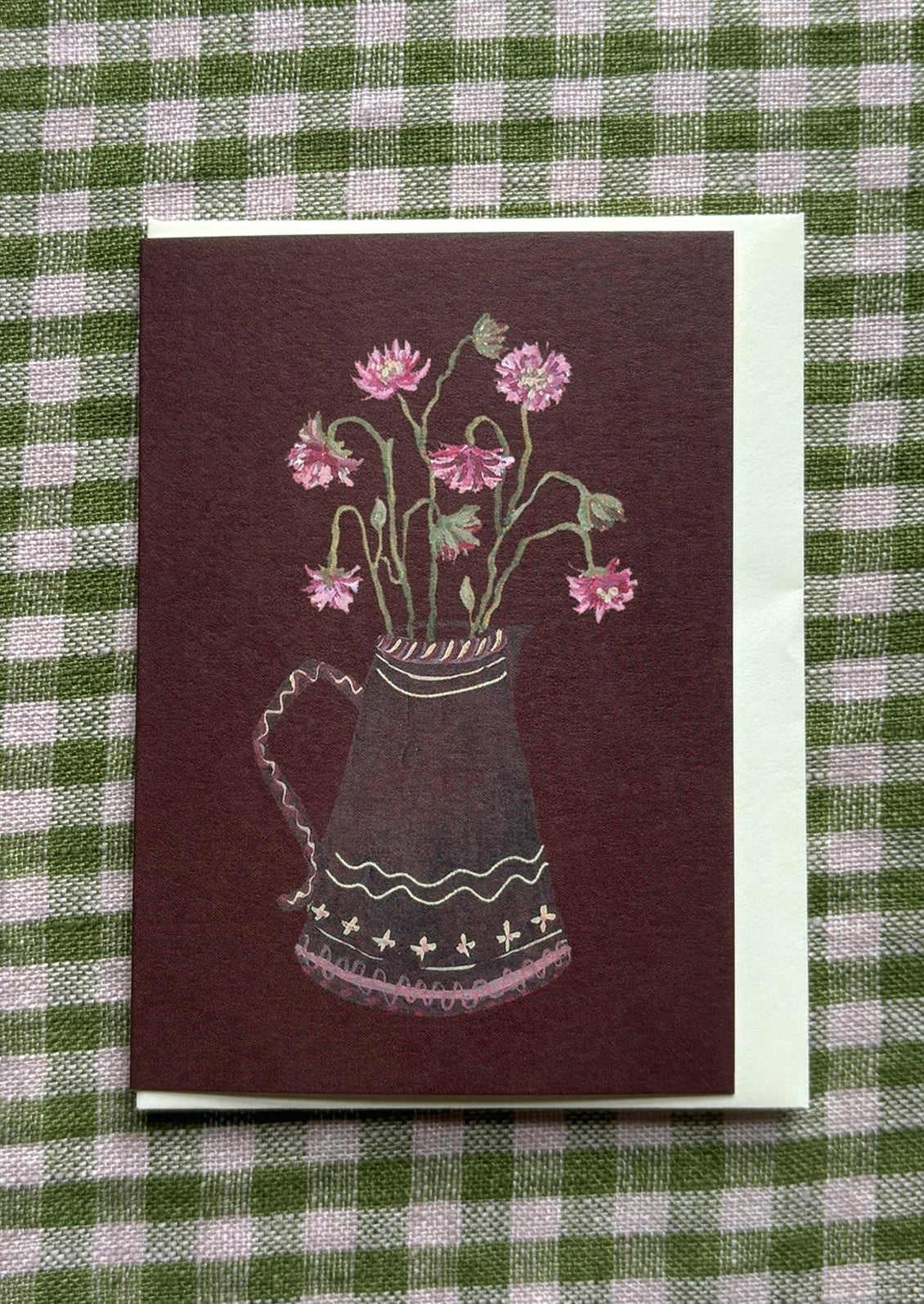 Card with design of a pitcher of flowers on a green and white checkered background