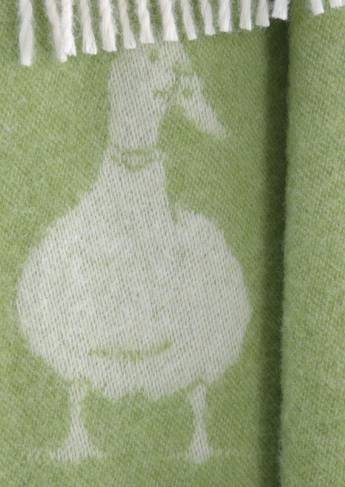 A close-up of a woven textile in light olive green with a large white duck silhouette and white fringe along the top edge.