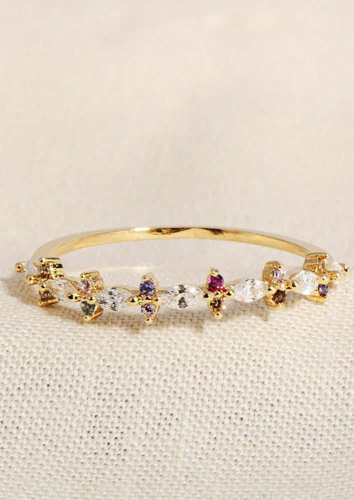 A gold ring with clear crystals surrounded by alternating color crystals.