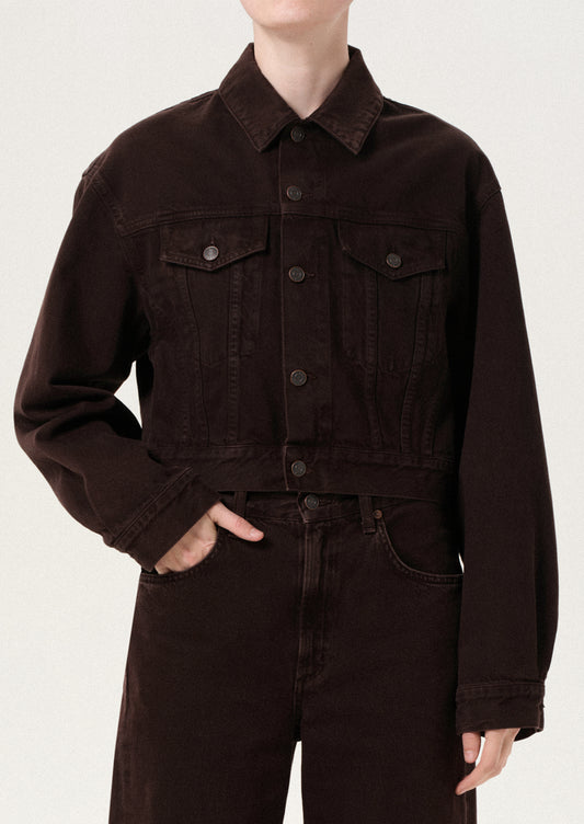 Person wearing a brown jacket and pants on a white background