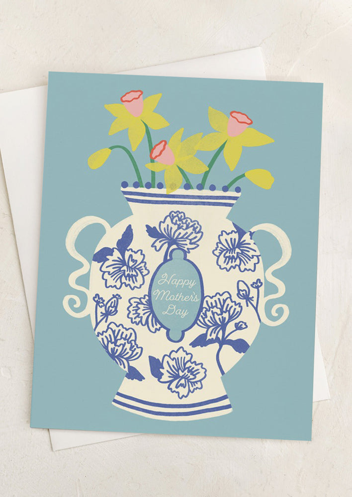 A blue card with illustration of daffodils in chinoiserie vase, text reads "Happy Mother's Day".