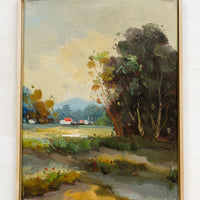 1: A framed landscape oil painting of trees and houses near a creek.