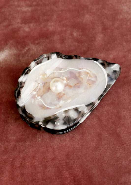 A hair claw in the shape of an oyster.