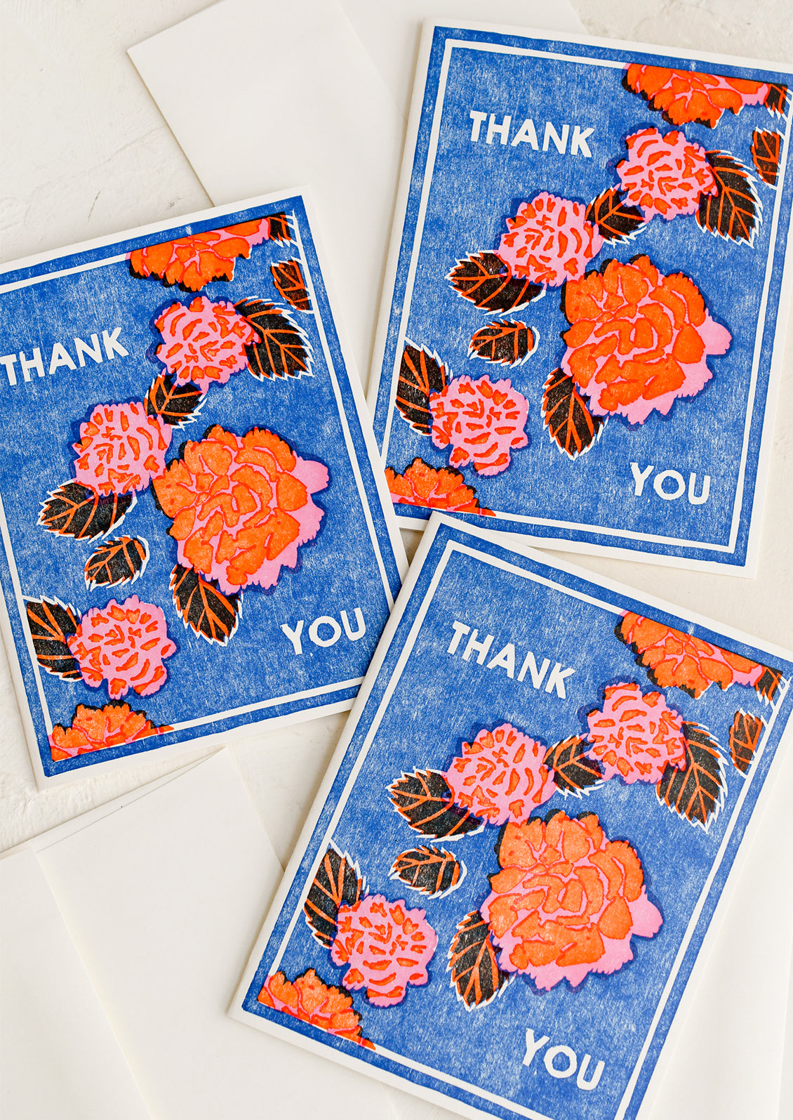 Blue thank you cards with red floral pattern.