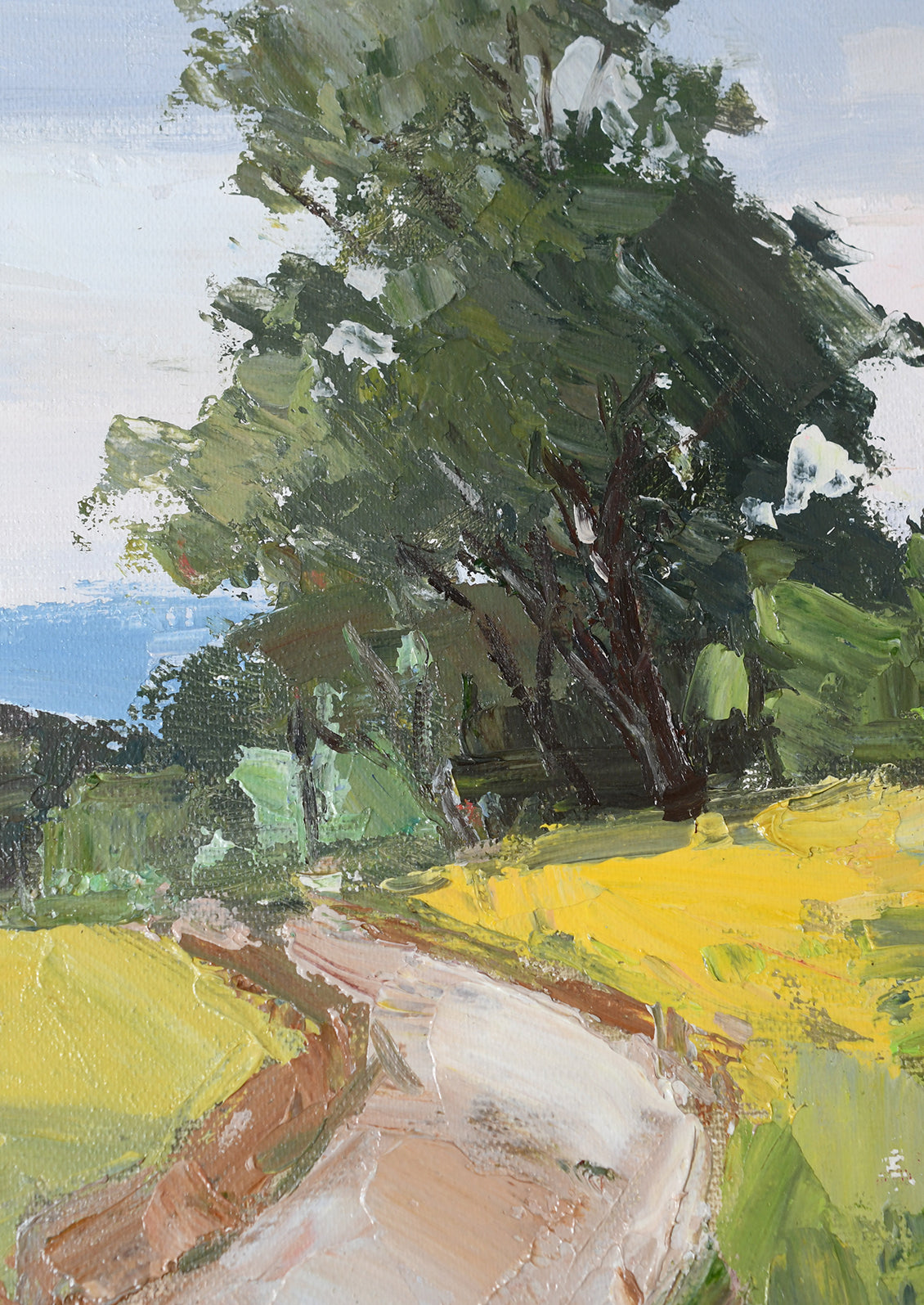 Impressionistic landscape painting of a winding path leading through bright yellow fields toward a large green tree under a pale sky.