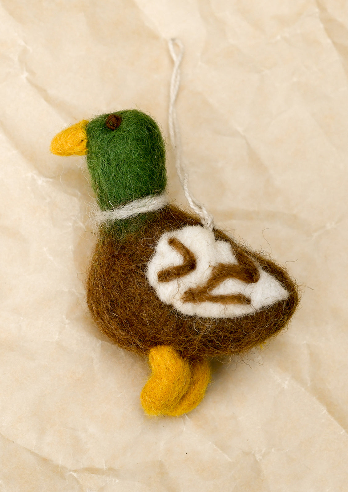 A small felted wool ornament depicting a mallard duck.