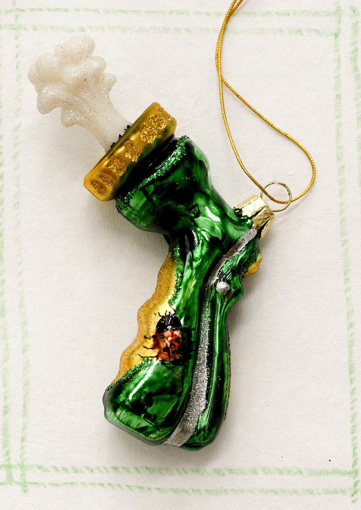 A glass holiday ornament depicting the sprayer attachment part of a garden hose.