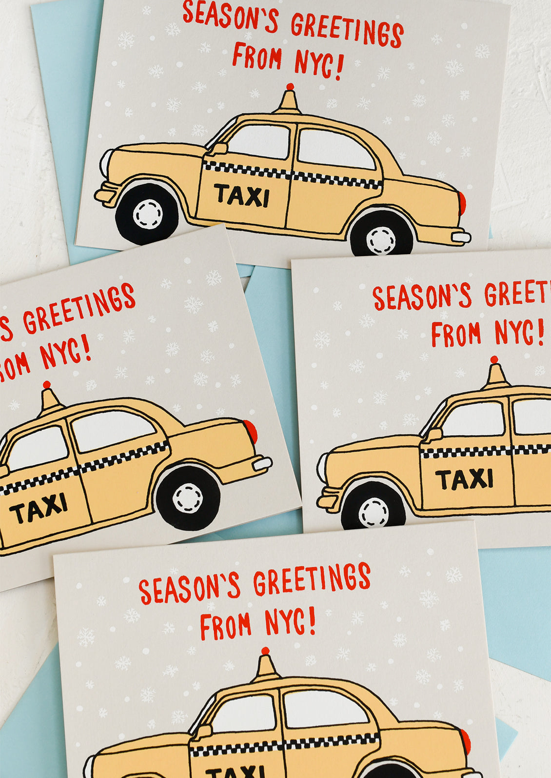 A set of cards with screen printed taxi design, text reads "Season's Greetings from NYC!".