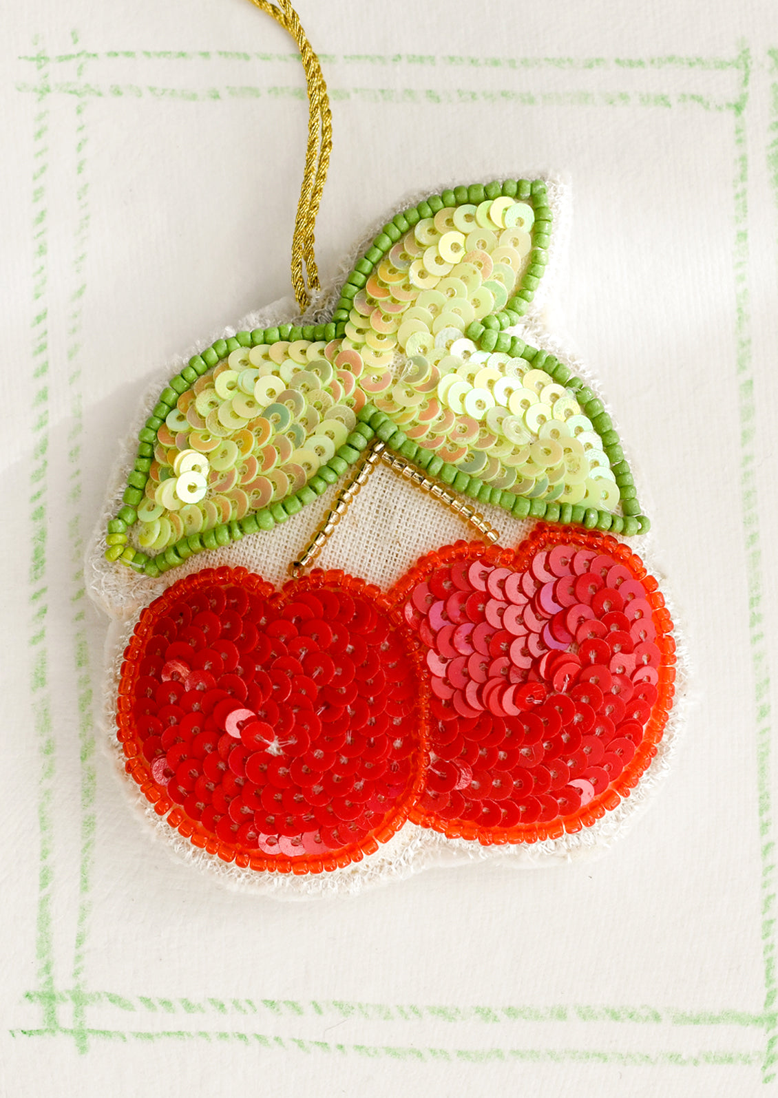 A sequined cotton ornament depicting a double cherry.