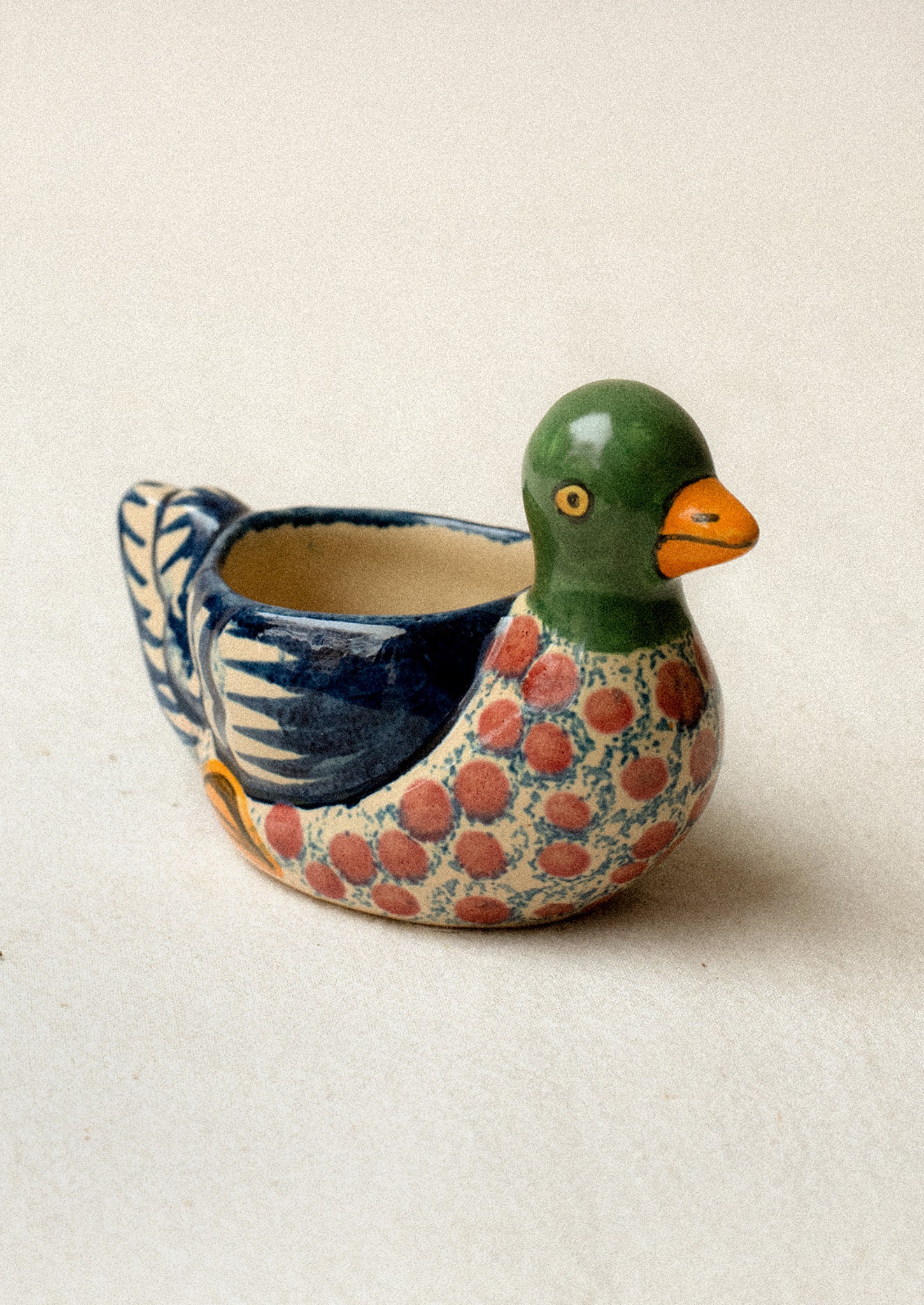 A hand-painted egg cup in the shape of a duck.